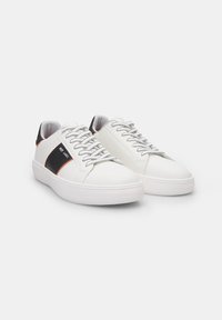 Valged nahksneakerid tekstureeritud viimistlusega, mustade aktsentidega, hallide paeltega ja valge kummitaldaga. Minimalistlik disain.