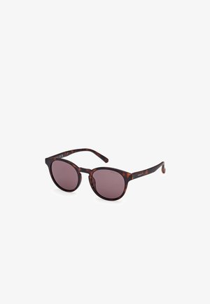 Gafas de sol redondas con un marco de patrón carey, lentes oscuros y brazos elegantes. Marca visible en los lados.