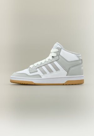 Άσπρο και ανοιχτό γκρι ψηλό παπούτσι Adidas με λευκά κορδόνια και καουτσούκ σόλα σε ουδέτερο φόντο, πλαϊνή όψη που δείχνει τις τρεις ρίγες.