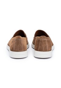 Brune ruskind slip-on sko med rund tå, hvid gummisål og minimalistiske syninger detaljer bagpå.