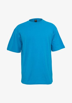 Tričko s krátkym rukávom v jasne modrej bavlne. Má klasický okrúhly výstrih a voľný strih. Bez výrazných vzorov alebo kovových detailov.