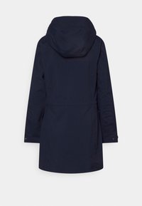 Námořnická modrá nepromokavá bunda s kapucí, dlouhými rukávy a staženým pasem. Má minimalistický design a skryté zapínání.