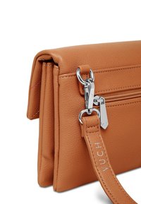 Hnědá kožená taška s texturovaným povrchem, vybavená zipovou přihrádkou a stříbrným kovovým příslušenstvím. Obsahuje popruh s raženým textem.