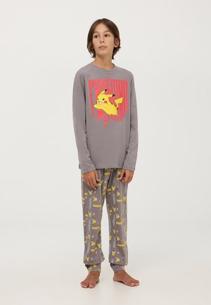 Maglietta grigia a maniche lunghe con grafica di Pikachu e testo rosso "Pokémon", abbinata a pantaloni da pigiama grigi con motivi gialli di Pikachu.