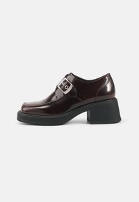 Burgundy patent leather shoes with a square toe, block heel, and a side buckle detail. Features a smooth finish and soft texture.