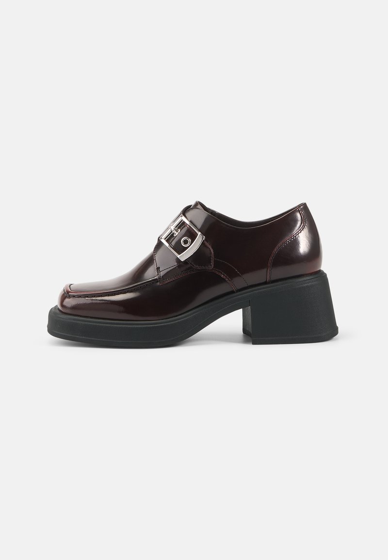 Burgundy patent leather shoes with a square toe, block heel, and a side buckle detail. Features a smooth finish and soft texture.