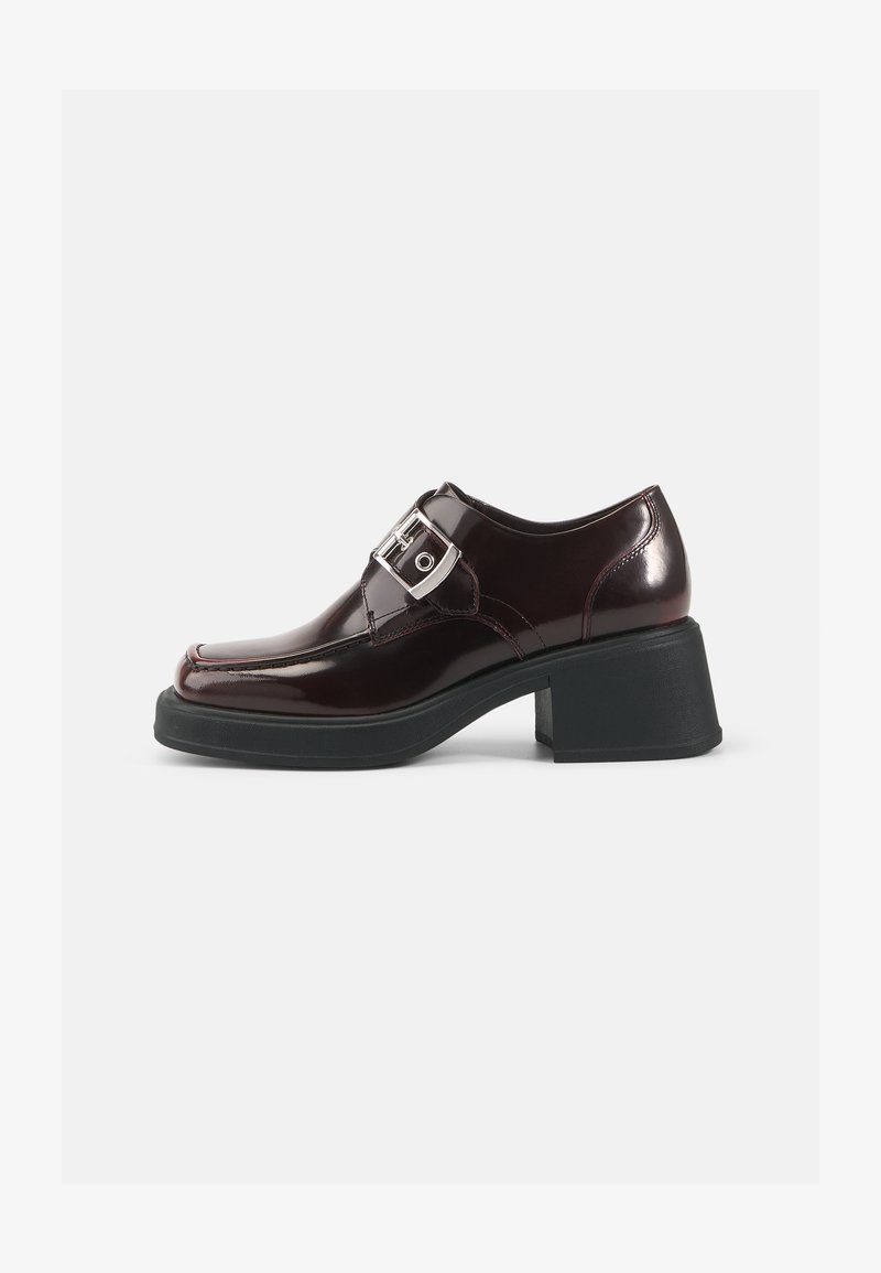 Burgundy patent leather shoes with a square toe, block heel, and a side buckle detail. Features a smooth finish and soft texture.