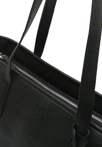 Čierna kožená nákupná taška s dvoma remienkami, horným zipsovým uzáverom a jemne vyrazeným logom na textúrovanom povrchu.