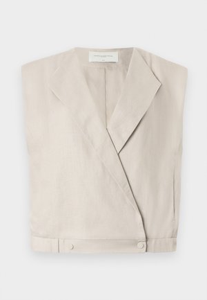 Haut wrap en lin beige clair avec un col, des manches allongées et des boutons-pression à l'ourlet pour un ajustement structuré.