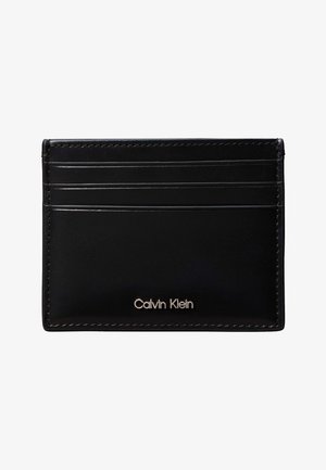 Sort læderkortholder med tre kortholdere og "Calvin Klein"-logo i sølvmetal foran i midten.