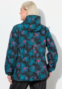 Blommönstrad jacka med svart bas och teal- samt rosa blommor, en huva och strassdetaljer längs ryggen.