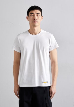 White cotton t-shirt with a round neckline and short sleeves. Features a small multicolored logo "ASPE SI" on the bottom left.