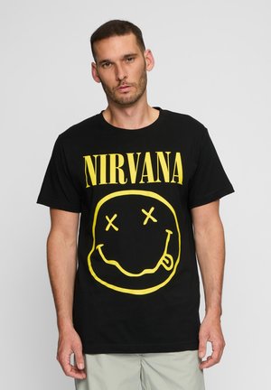 Black cotton T-shirt featuring a large yellow "NIRVANA" text and a smiley face graphic with X eyes, displayed on a plain background.
