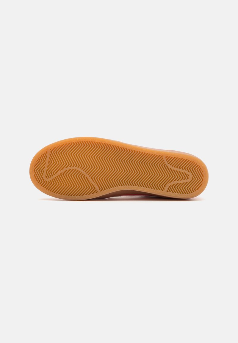 Suela de zapato de goma con un patrón de espiga, que presenta una textura suave y un color naranja claro. Los bordes son redondeados para mayor comodidad.