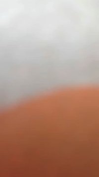 Utydelig oransje overflate med en jevn tekstur som går over til et lys grått område; myk fokus skjuler fine detaljer og trekk.