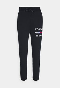 Schwarze Jogginghosen mit einem elastischen Bund und Kordelzug, versehen mit einem gedruckten Logo und Design in Weiß, Rot und Blau am rechten Bein.