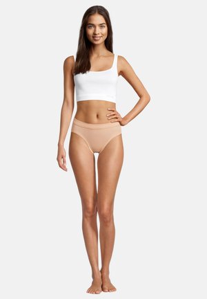 Top corto bianco in cotone abbinato a culotte nude a vita alta. Entrambi i capi hanno una texture liscia e un design semplice e contemporaneo.