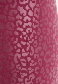 Tissu rose avec une finition texturée et mate, présentant un motif de léopard subtil dans des tons de rose plus foncé.