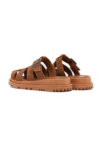Sandali in suede marrone con più cinturini, una fibbia in metallo e una suola in gomma spessa con un motivo di battistrada testurizzato.