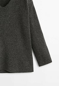 Mørkegrå sweater i blødt strikket stof. Har rund halsudskæring, lange ærmer og ribbet kant med sideslidser for ekstra detalje.