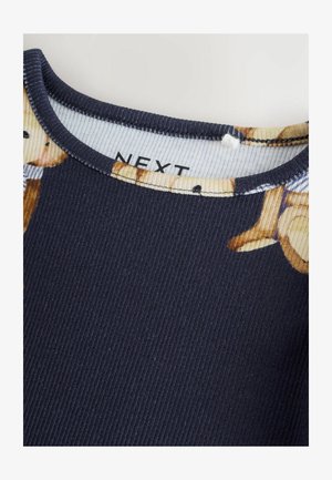 Tessuto a coste blu navy con stampa di orsi dai colori chiari sul colletto. Texture liscia e design classico del colletto rotondo. Etichetta del marchio visibile.