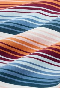 Gros plan sur un tissu à rayures horizontales orange, bordeaux, bleu marine, bleu et blanc, montrant la texture et de légers plis.