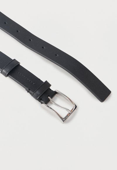 Μαύρη δερμάτινη ζώνη με αγκράφα από ασημένιο μέταλλο και πολλαπλές τρύπες ρύθμισης σε λευκό φόντο.