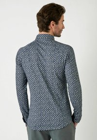 Marineblaue langärmlige Hemd mit geometrischem Muster, strukturiertem Stoff, Button-Down-Kragen und Manschetten. Verfügt über einen geraden Saum und eine taillierte Passform.