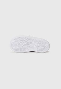 Semelle de sneaker blanche avec une semelle en caoutchouc texturée. Présente un motif de semelle en zigzag et un logo embossé dans la zone du talon pour l'adhérence et le style.