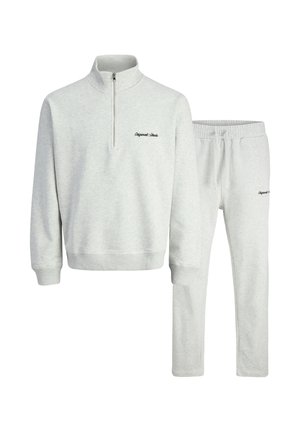 Light gray sweatshirt with a quarter zip and ribbed collar, paired with matching elastic waistband pants. Features subtle embroidered text.