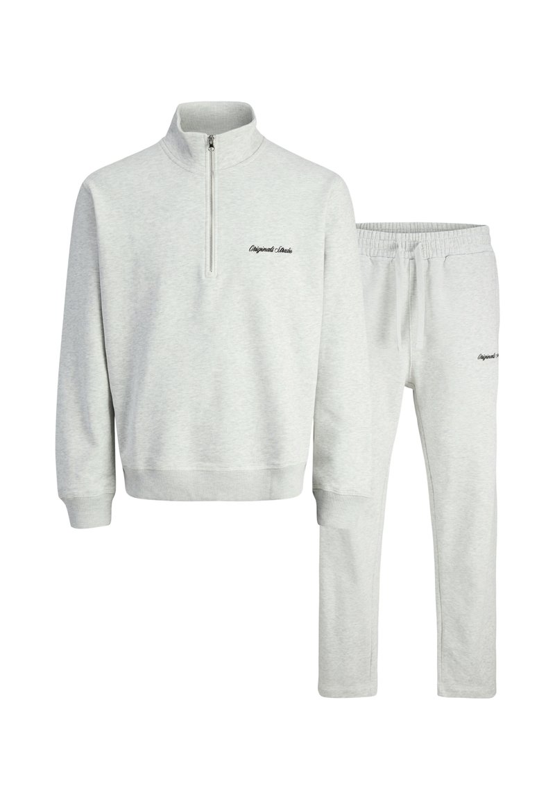 Hellgraues Sweatshirt mit einem Viertelreißverschluss und geripptem Kragen, kombiniert mit passenden Hose mit elastischem Bund. Verfügt über dezent gestickten Text.