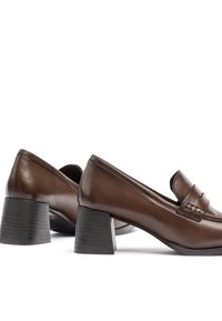 Mocasines de cuero marrón con tacón bajo y una banda elevada en la parte superior. Textura suave con un sutil detalle de costura.