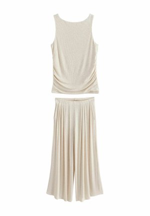 Ärmelloses beiges Tanktop kombiniert mit weit geschnittenen, hoch taillierten beigen Hosen, beide aus weichem, leichtem Stoff.
