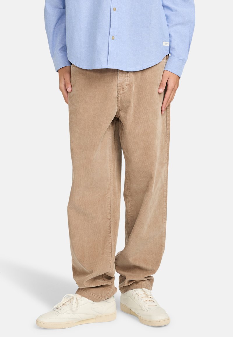 Beige corduroy pants with relaxed fit, featuring vertical ribbing. Paired with white sneakers and a light blue button-up shirt.