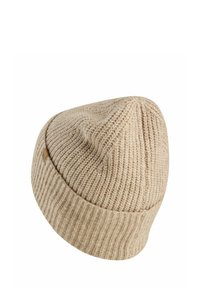 Tan knit beanie with a textured pattern, featuring a tapered top, ribbed cuff, and a small leather logo tag on the side.