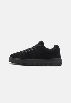 Sneakers neri con tomaia in suede testurizzato, punta tonda e suola piatta in gomma. Presentano sei paia di occhielli per il fissaggio dei lacci.
