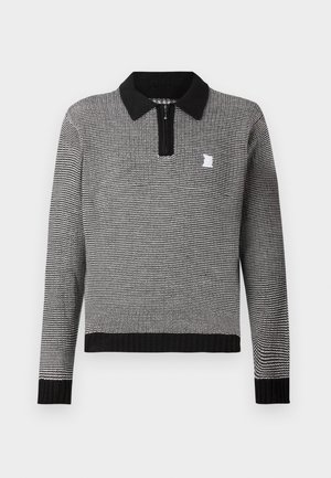 Pletený sveter s čierno-bielym vzorom, s límcom na zips a rebrovými manžetami. Malý logotyp na hrudi.