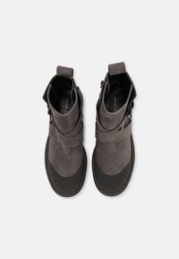 Šedé semišové kotníkové boty s kulatou gumovou podešví, s ohrnovacím lemem, zipovým zapínáním a dekoračním páskem.