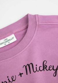 Fioletowa bluza z okrągłym dekoltem, teksturowaną tkaniną i czarnym napisem "Minnie + Mickey".