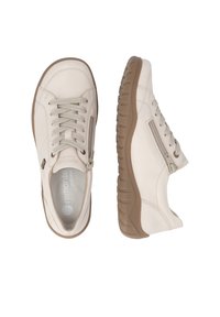 Paire de baskets en cuir beige avec semelles marron, lacets, fermetures éclair latérales et nom de marque visible à l'intérieur d'une chaussure.