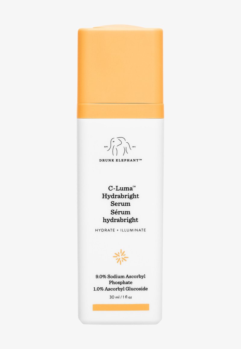 White bottle with an orange cap, featuring black text including "C-Luma Hydrabright Serum," and a graphic of a stylized sunburst at the bottom.