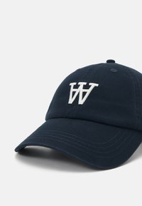 Navy cotton baseball cap with a structured front, curved brim, and white embroidered "W" logo on the front. Six ventilation eyelets.