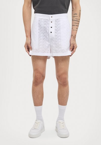 White shorts with textured embroidery, a high waist, and five-button closure. Accented with decorative eyelet patterns for added detail.