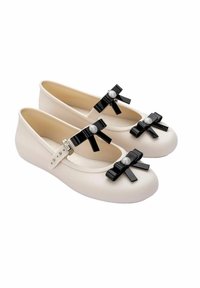 Bailarinas de crema mate con lazos negros y acentos de perlas, con punta redondeada y correa ajustable para un ajuste seguro. Textura suave.