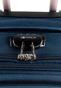Tela de equipaje azul marino con una textura diagonal, que cuenta con un candado de combinación negro ITACA y dobles cremalleras de metal.