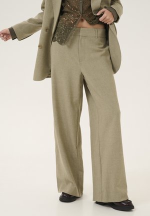 Wide-leg trousers in a light olive-green fabric, featuring a subtle texture and clean lines. Paired with a darker, lacy top.