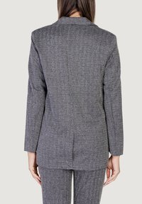 Blazer grigio a motivo a zig zag con maniche lunghe e rever a punta, caratterizzato da una vestibilità sartoriale e una texture liscia. Adatto per abbigliamento formale.