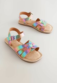 Multicolored sandals featuring iridescent straps with a snakeskin pattern, a cushioned tan footbed, and a silver buckle detail.