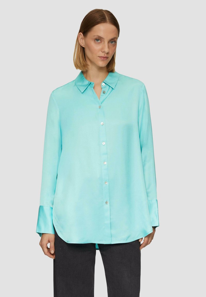 Licht turquoise zijden blouse met eenopstaande kraag, knoopsluiting aan de voorkant, lange mouwen en een afgeronde zoom. Heeft een gladde textuur en een glanzende afwerking.