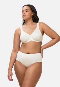 Witte naadloze beha met kantdetails, brede bandjes en beugels, gecombineerd met bijpassende hoge slip met subtiele textuur.